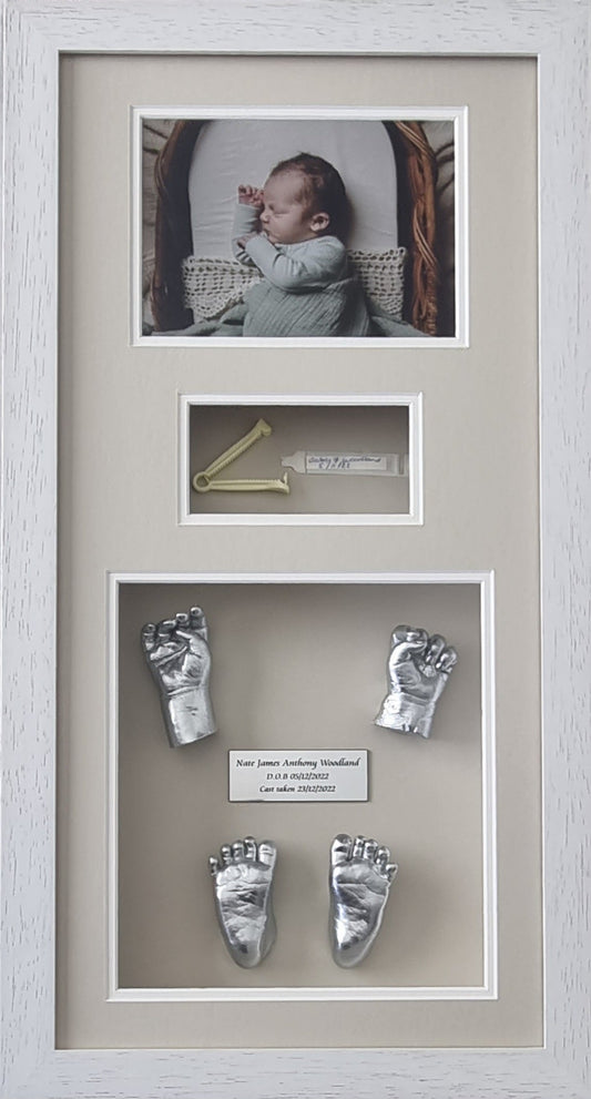 Framed baby photo with silver hand and footprints on a neutral background